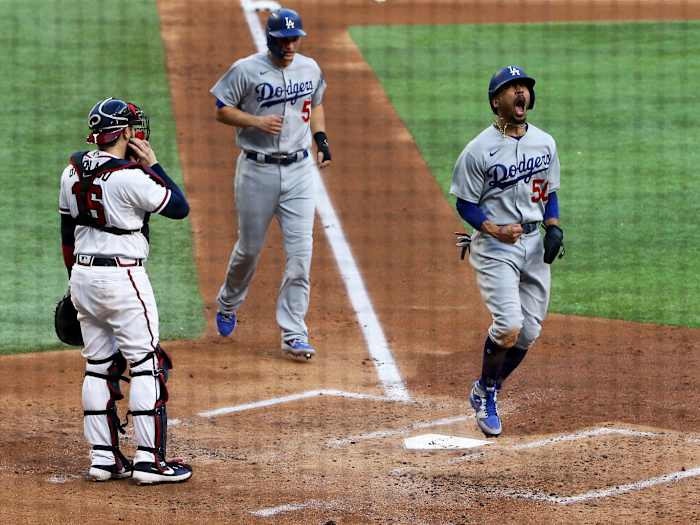 Oct 14, 2020; Arlington, Texas, USA; Los Angeles Dodgers right fielder Mookie Betts (50) celebrates after scoring against Atlanta Braves catcher Travis d'Arnaud (16) during game three of the 2020 NLCS at Globe Life Field.